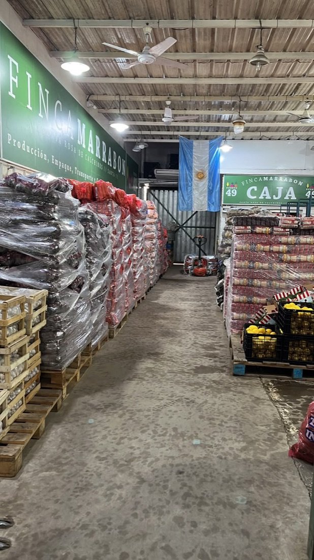 El puesto de Finca Marrabon en el mercado, con productos y cartelería de la marca
